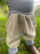 Lade das Bild in den Galerie-Viewer, Fischgräthose Bio Jacquard Sweat Hose Beige Grau Uni Taschen Mitwachshose
